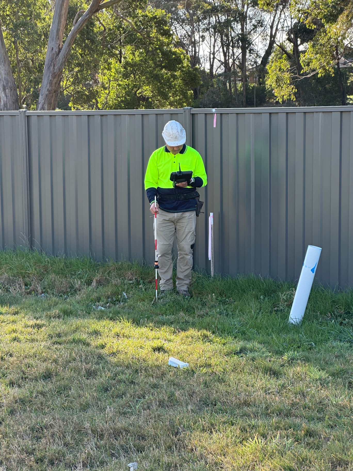 Surveyor taking on-site measurement and as-built verification checks mid-build